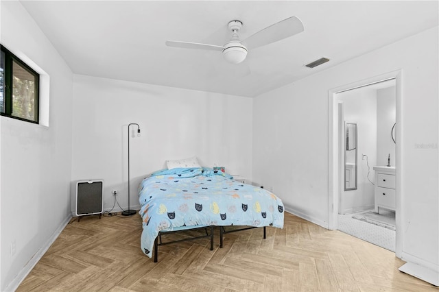 bedroom featuring ceiling fan, ensuite bathroom, and light parquet floors