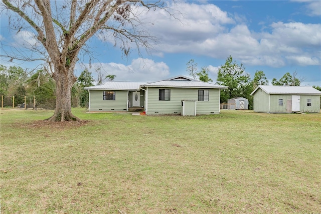 back of property featuring a lawn and a storage unit