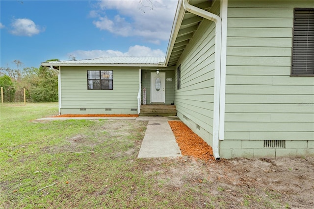 doorway to property featuring a lawn