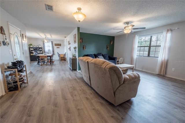 living room with ceiling fan, hardwood / wood-style floors, and a textured ceiling