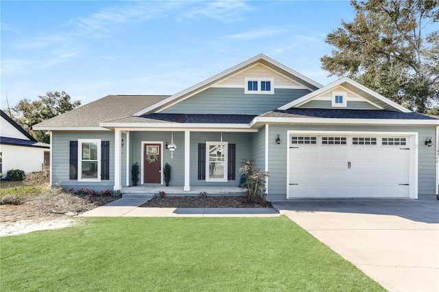 view of front of home featuring a garage, covered porch, and a front yard