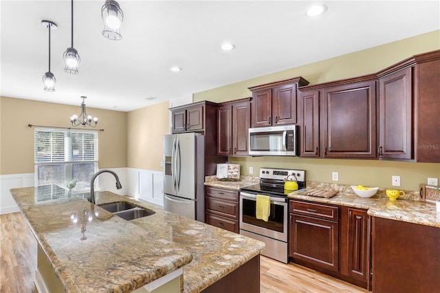 kitchen with sink, decorative light fixtures, a center island with sink, and appliances with stainless steel finishes