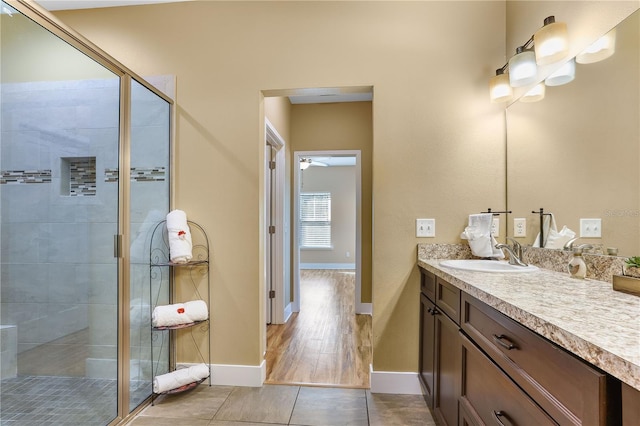 bathroom featuring vanity, a shower with shower door, tile patterned floors, and ceiling fan