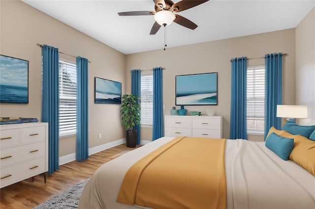 bedroom featuring multiple windows, ceiling fan, and light hardwood / wood-style floors