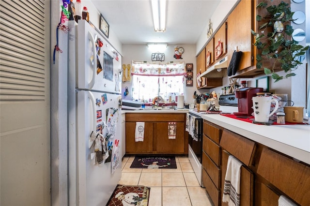 kitchen with sink, light tile patterned floors, and white appliances