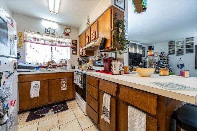 kitchen with white electric range oven, sink, and light tile patterned floors