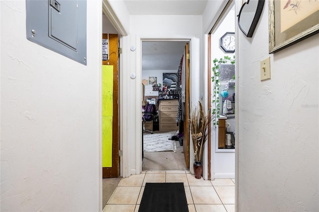 hallway with light tile patterned flooring and electric panel