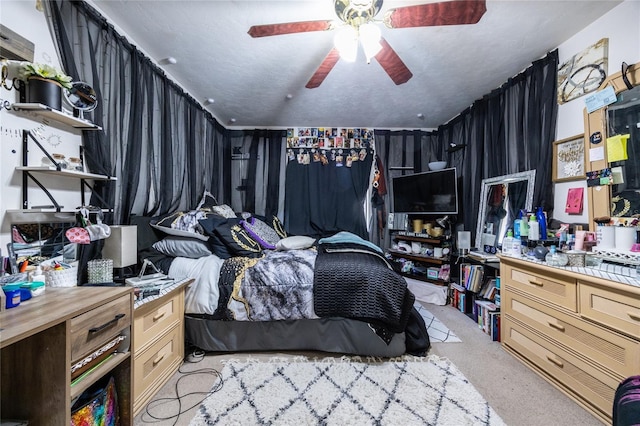 carpeted bedroom with ceiling fan and a textured ceiling