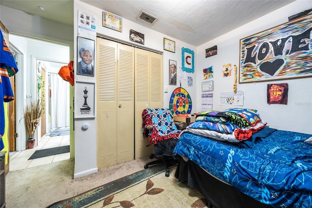 bedroom with light carpet, a closet, and a textured ceiling