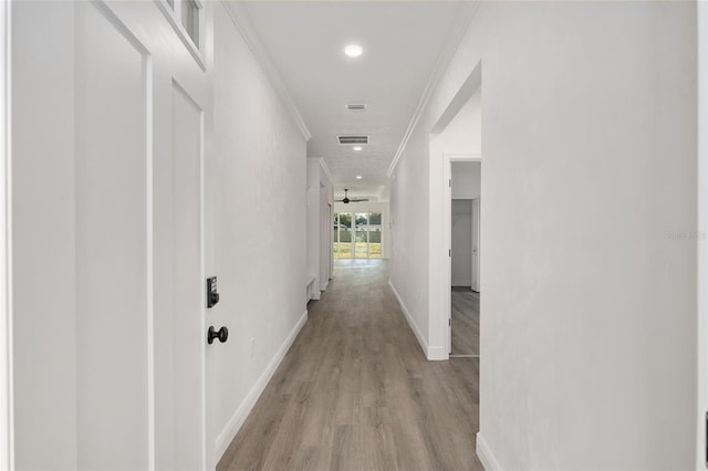 corridor with crown molding and light wood-type flooring