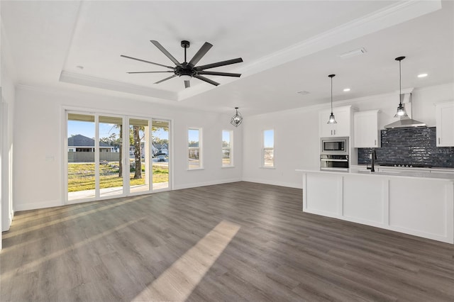 unfurnished living room featuring ornamental molding, a raised ceiling, and a wealth of natural light