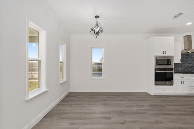 unfurnished dining area featuring crown molding and hardwood / wood-style floors