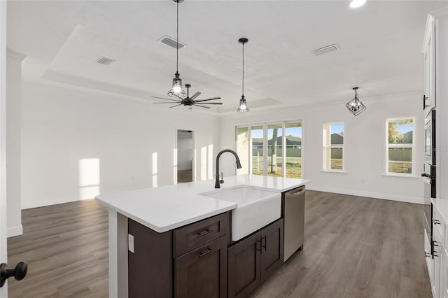 kitchen with sink, stainless steel appliances, a healthy amount of sunlight, white cabinets, and a raised ceiling