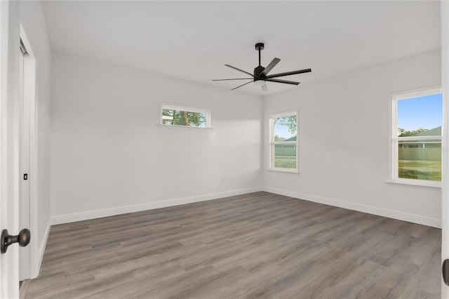 empty room with ceiling fan and light hardwood / wood-style floors