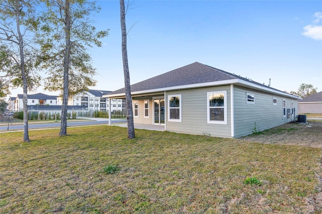 view of front of house with central AC and a front lawn