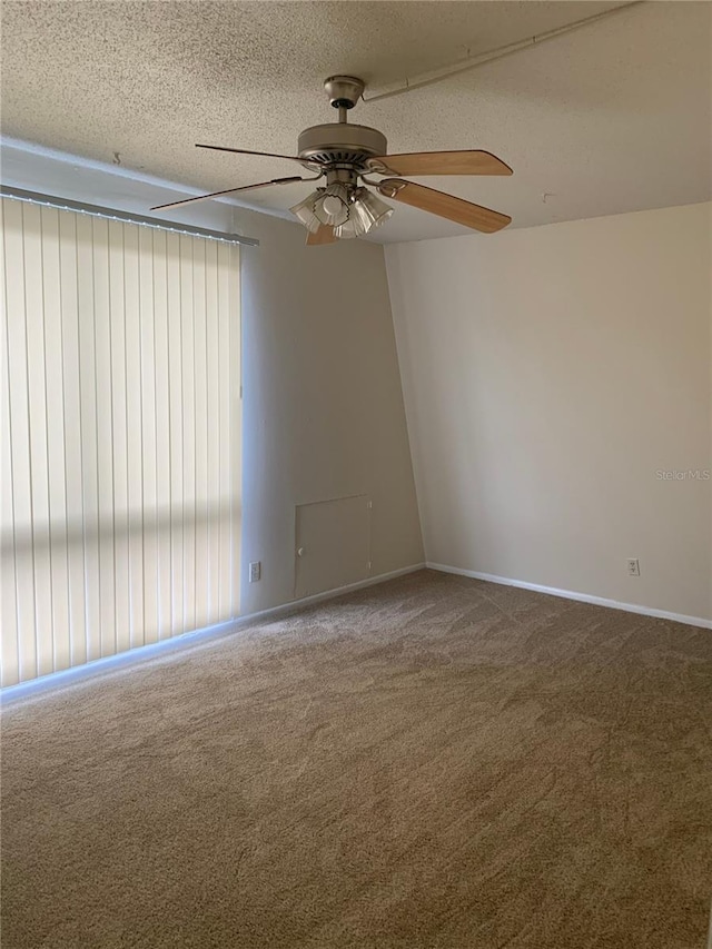 carpeted spare room with ceiling fan and a textured ceiling