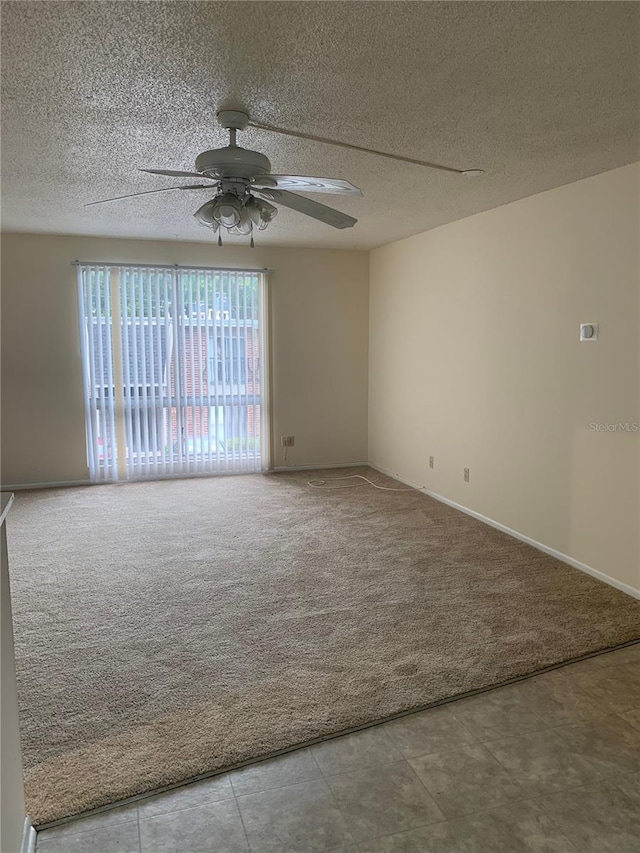 carpeted empty room with ceiling fan and a textured ceiling