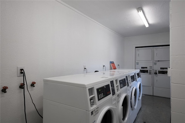 clothes washing area featuring stacked washing maching and dryer, washing machine and dryer, and a textured ceiling