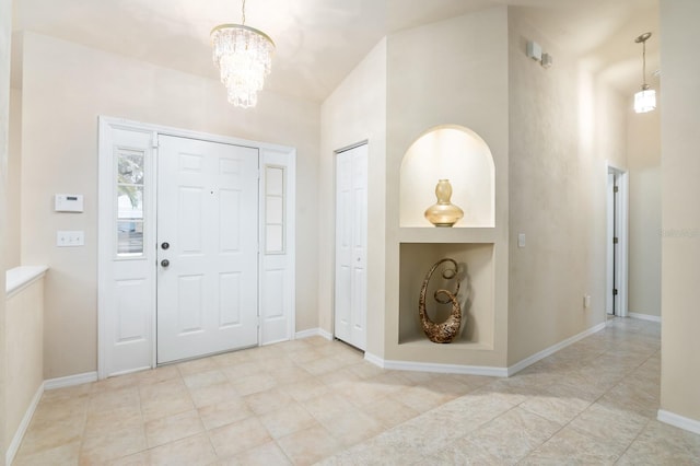 foyer entrance featuring a towering ceiling and a notable chandelier