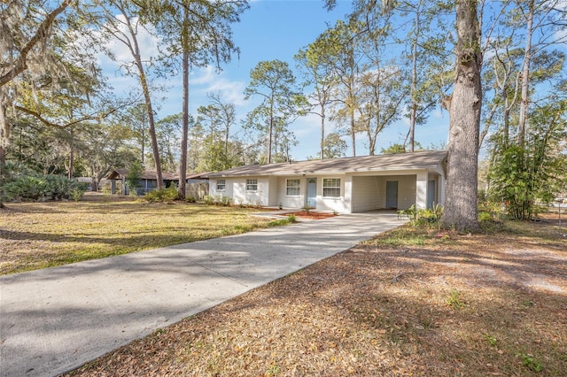 ranch-style home featuring a front lawn and a carport