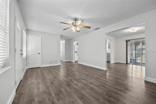 unfurnished living room with a textured ceiling, dark wood-type flooring, and ceiling fan