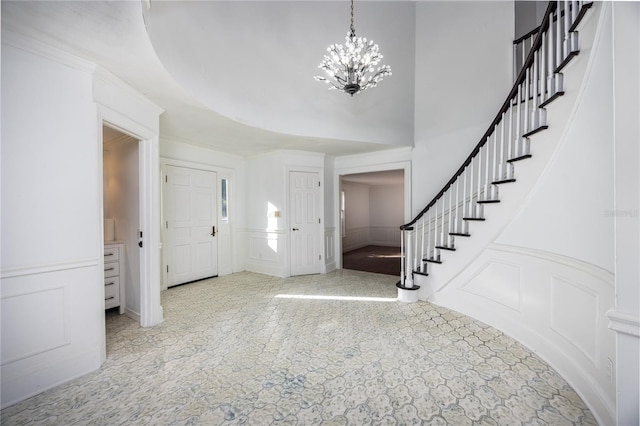 entryway with a notable chandelier and a towering ceiling