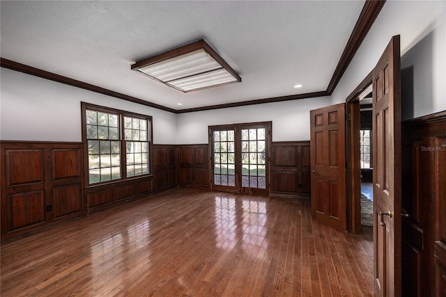 unfurnished room with crown molding, dark wood-type flooring, and french doors