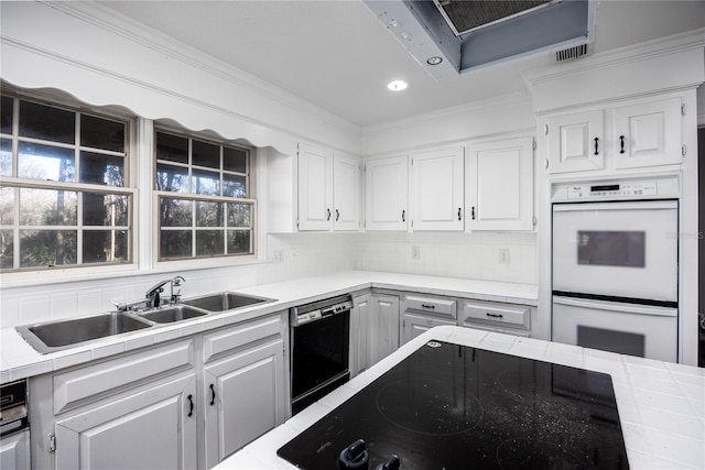 kitchen featuring sink, crown molding, white cabinetry, backsplash, and black appliances