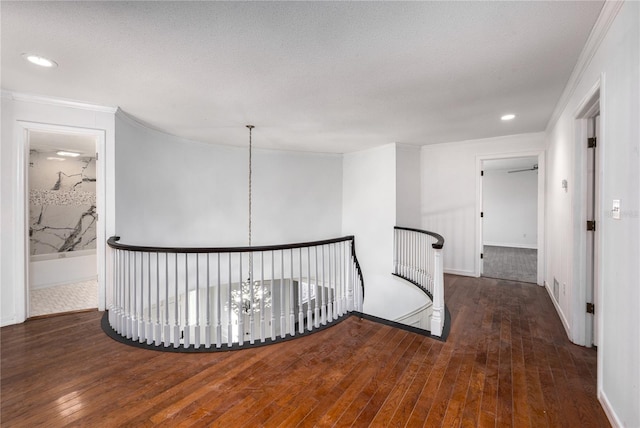 hall with ornamental molding, dark hardwood / wood-style flooring, and a chandelier