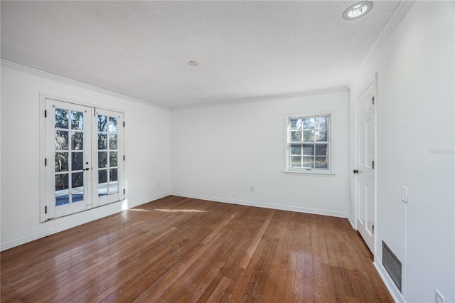 spare room featuring french doors, ornamental molding, wood-type flooring, and a textured ceiling