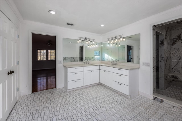 bathroom with ornamental molding, vanity, and a tile shower