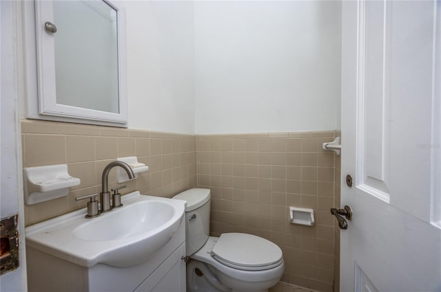 bathroom featuring vanity, toilet, and tile walls