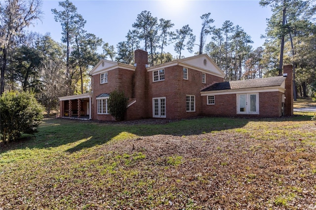 rear view of house with a yard and french doors