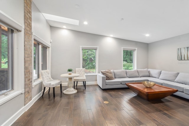 living room with dark hardwood / wood-style floors and vaulted ceiling with skylight