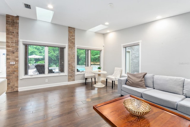 living room featuring dark hardwood / wood-style floors and a skylight