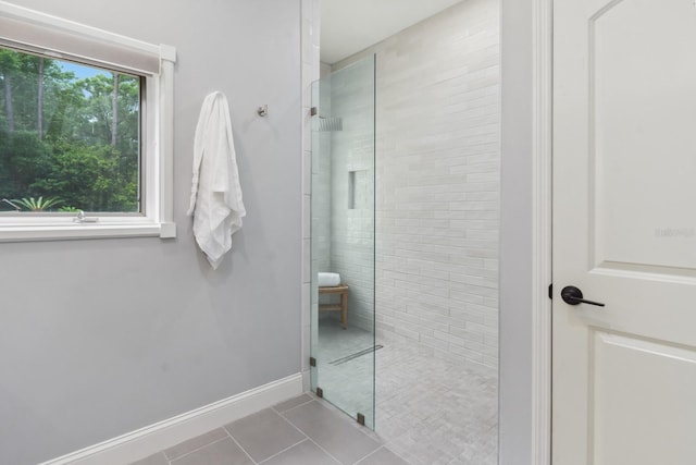 bathroom with tile patterned flooring and tiled shower