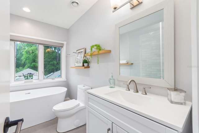 bathroom with vanity, a tub to relax in, and toilet