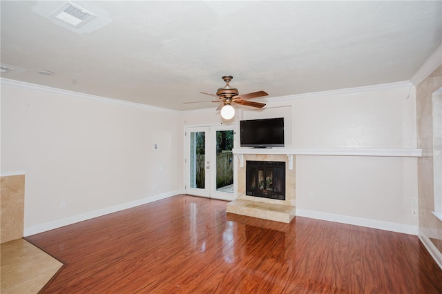 unfurnished living room with hardwood / wood-style floors, a fireplace, ornamental molding, and ceiling fan