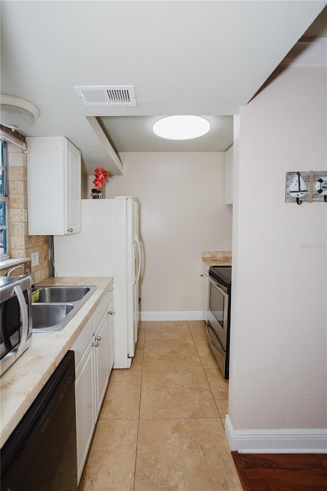 kitchen featuring sink, stainless steel range with electric cooktop, white cabinetry, black dishwasher, and backsplash