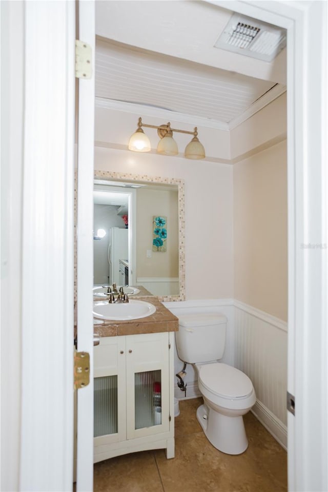 bathroom with crown molding, vanity, toilet, and tile patterned flooring