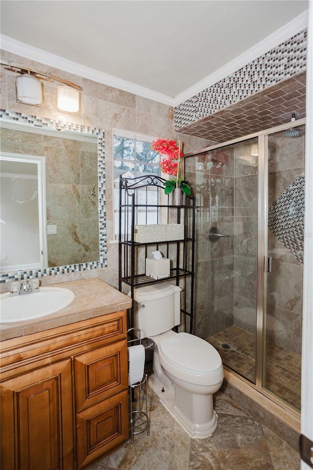 bathroom with crown molding, a shower with door, tile walls, vanity, and toilet