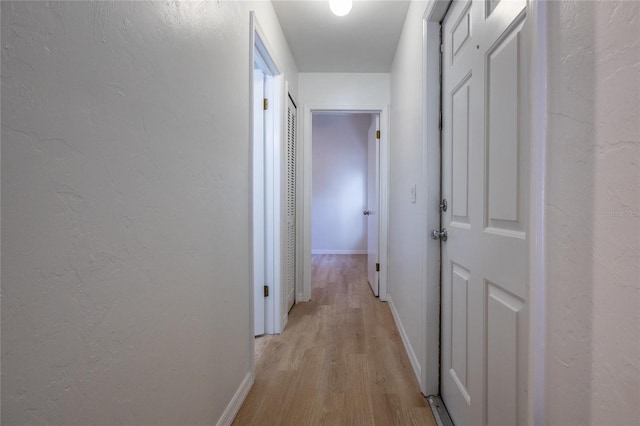 corridor with light hardwood / wood-style floors