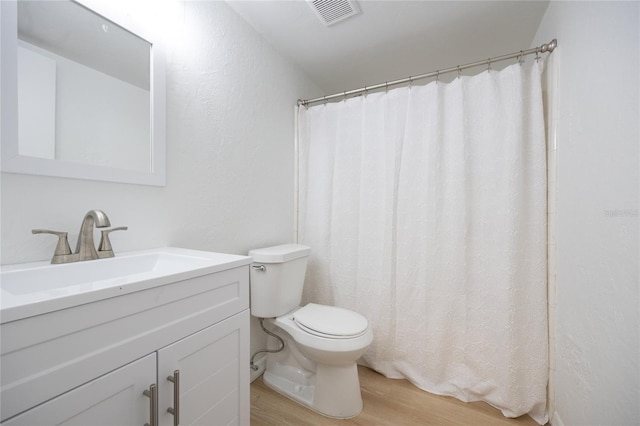 bathroom featuring vanity, wood-type flooring, and toilet