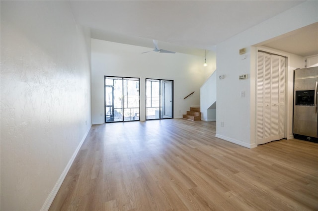 unfurnished living room featuring ceiling fan and light hardwood / wood-style flooring