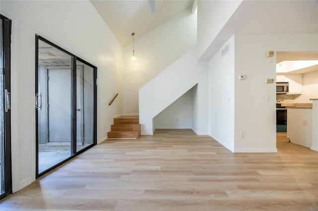 interior space featuring high vaulted ceiling and light wood-type flooring