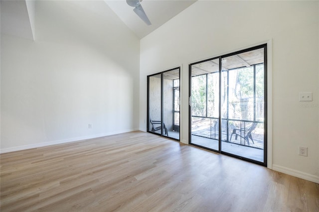 spare room with ceiling fan, high vaulted ceiling, and light hardwood / wood-style floors