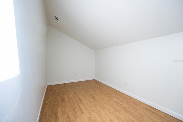 bonus room with lofted ceiling and light wood-type flooring