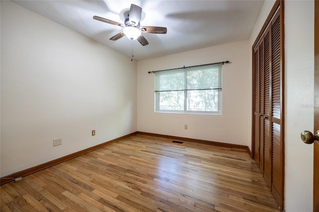 unfurnished bedroom featuring ceiling fan, a closet, and light wood-type flooring