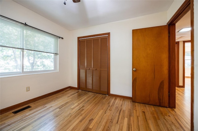 unfurnished bedroom featuring a closet and light wood-type flooring