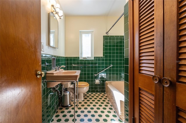 full bathroom with sink,  shower combination, tile walls, tile patterned flooring, and toilet